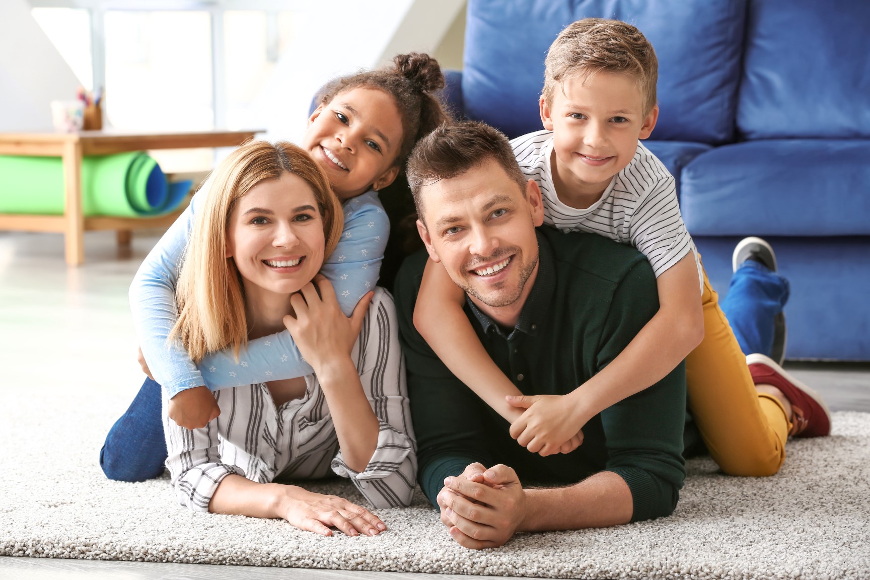 family posed on the floor of the living room